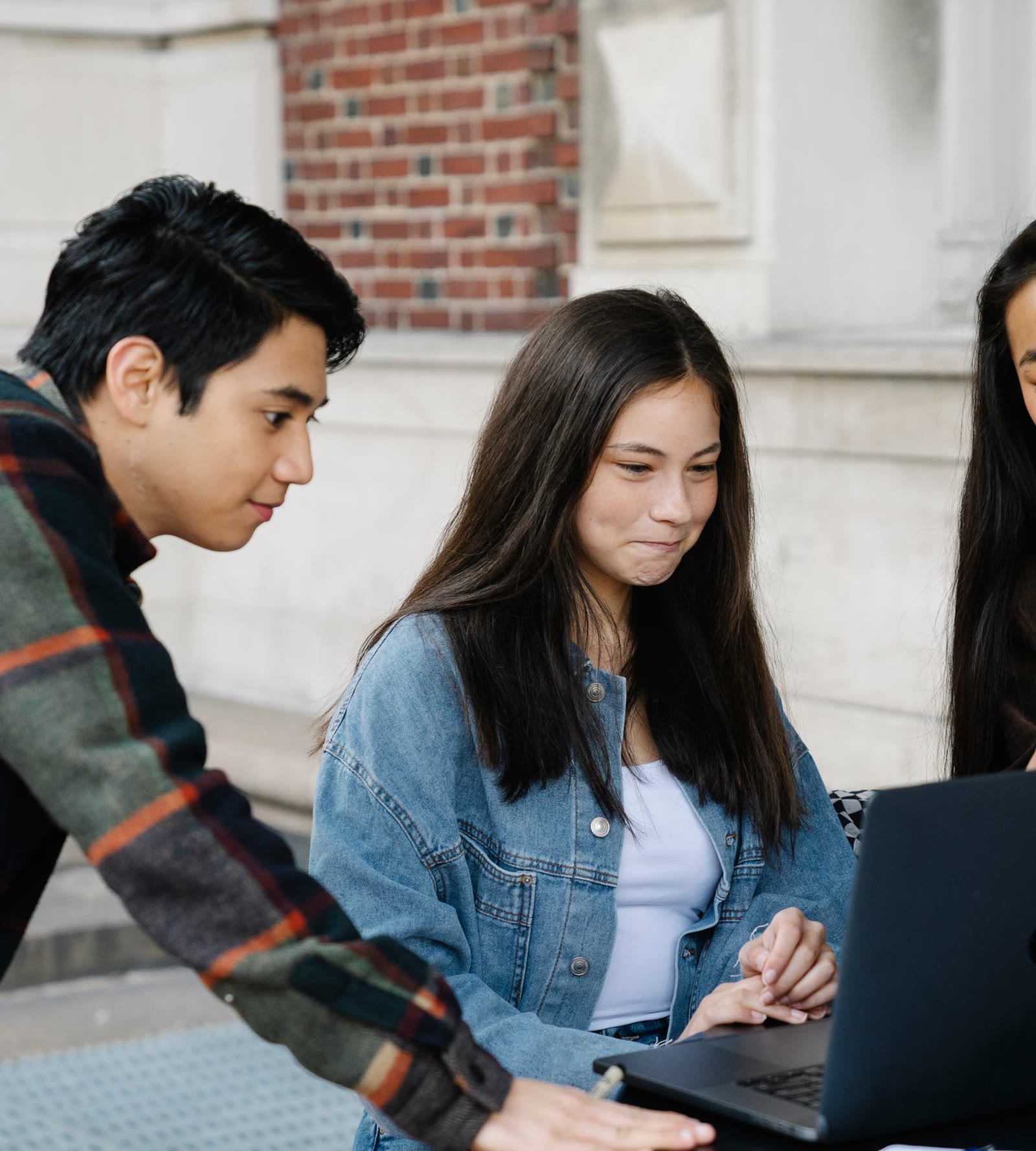Students collaborating around a laptop